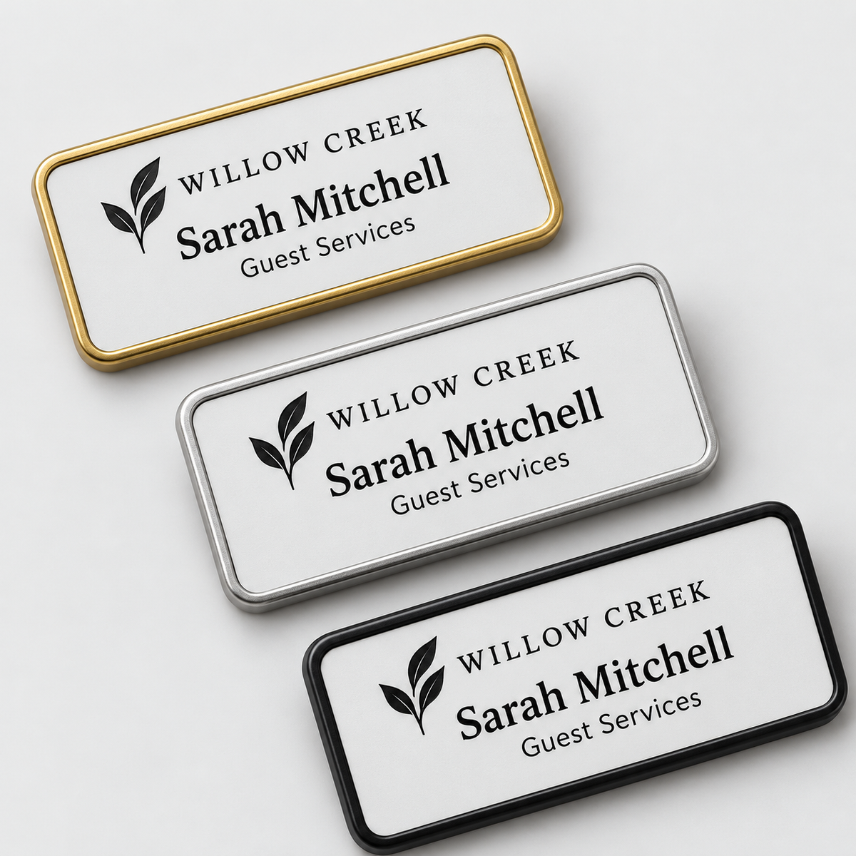 Rounded rectangular framed engraved plastic name badges in gold, silver and black