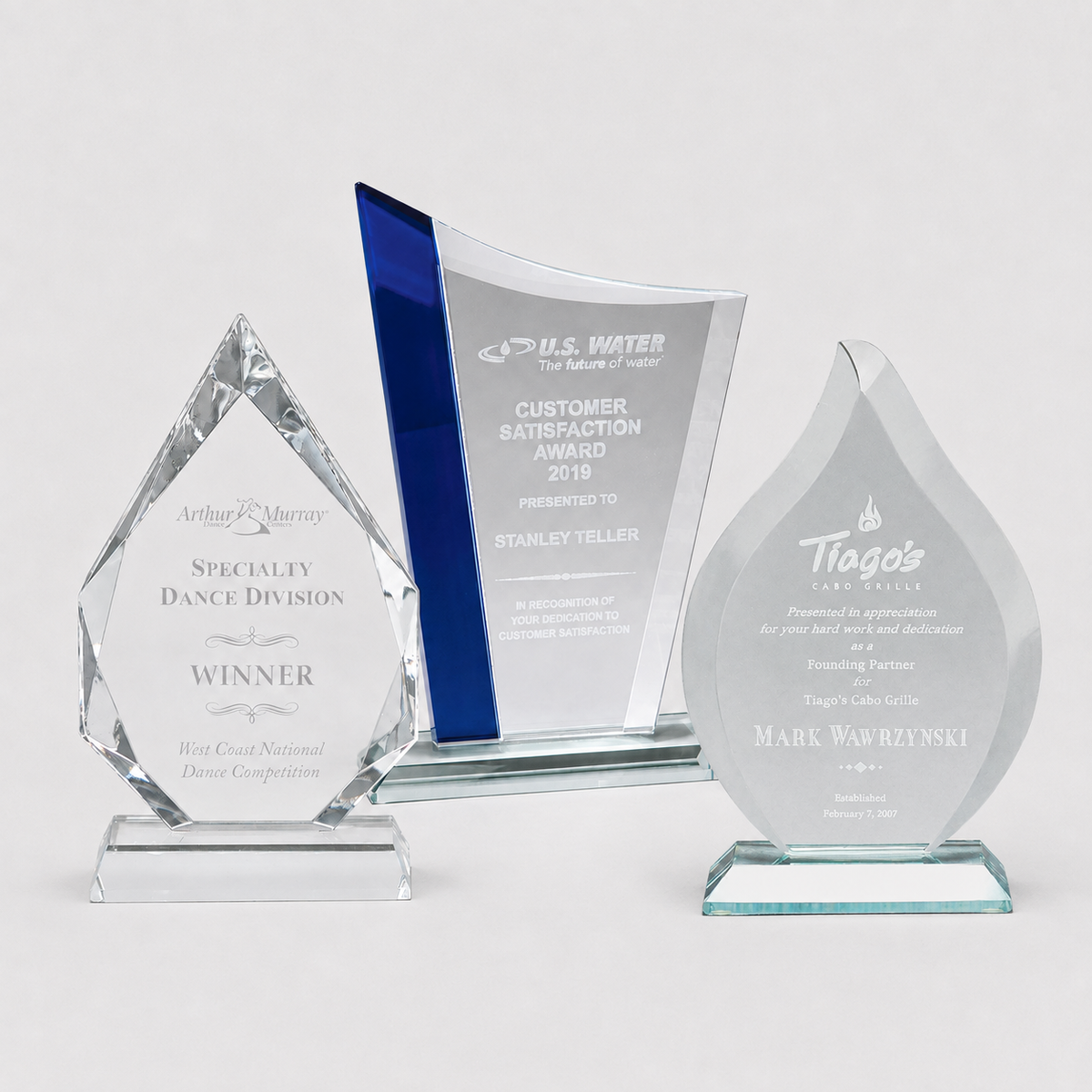 Assorted personalized crystal and glass awards in clear and colored styles
