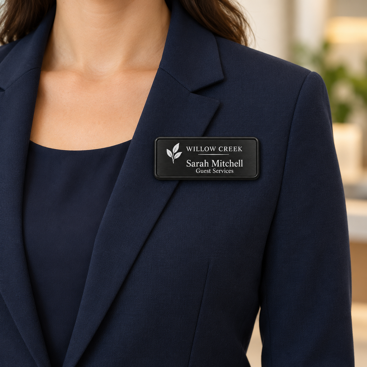 Framed engraved metal name badge worn on a navy blazer