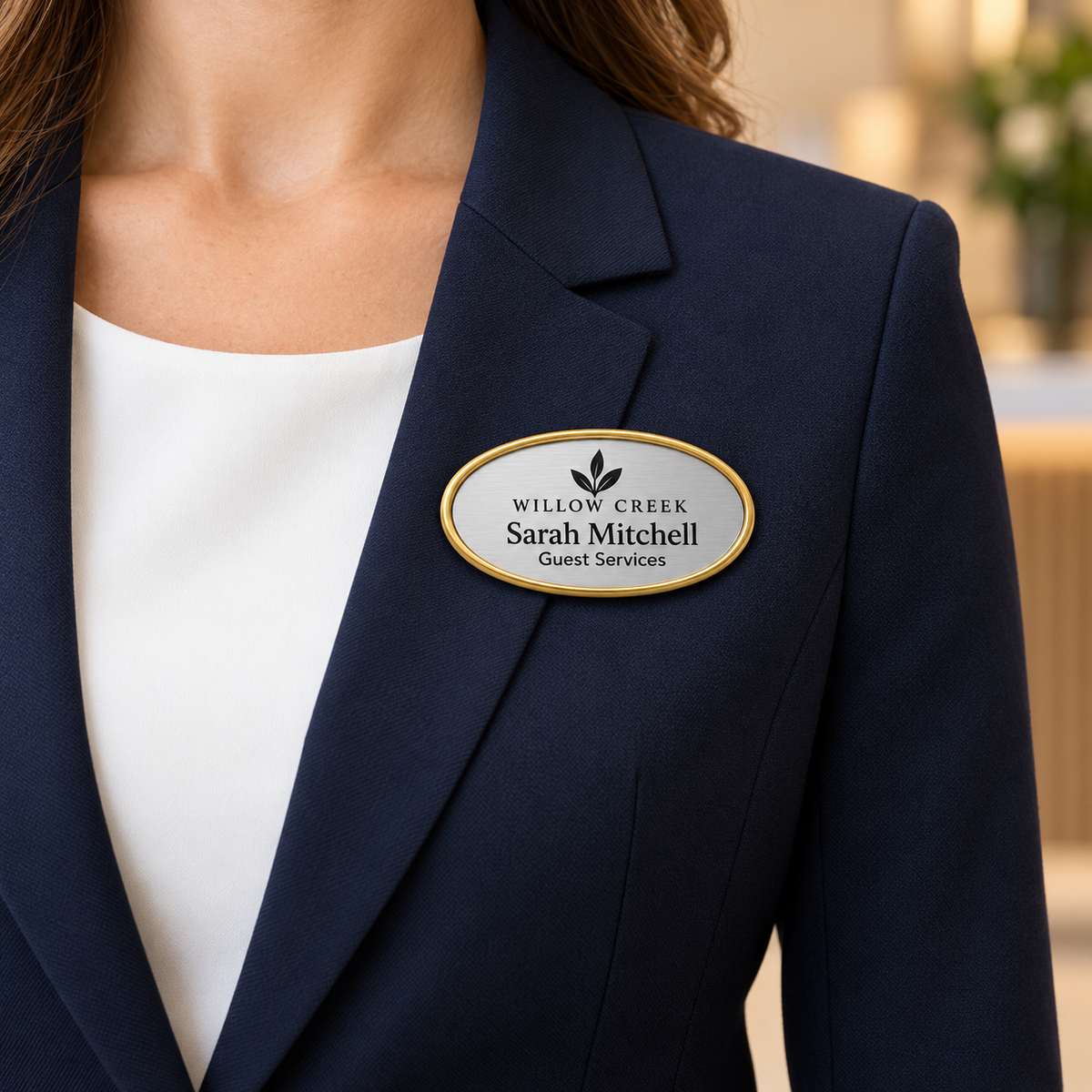 Oval framed engraved plastic name badge worn on a navy blazer